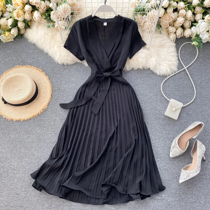Robe plissée longueur genou à taille haute et encolure en V dans une couleur unie élégante