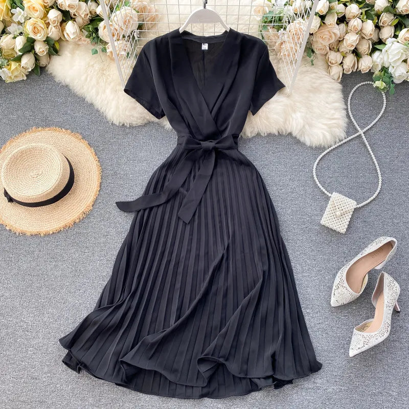 Robe plissée longueur genou à taille haute et encolure en V dans une couleur unie élégante