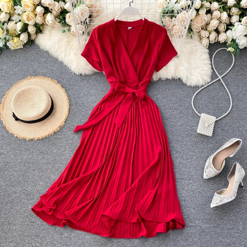 Robe plissée longueur genou à taille haute et encolure en V dans une couleur unie élégante